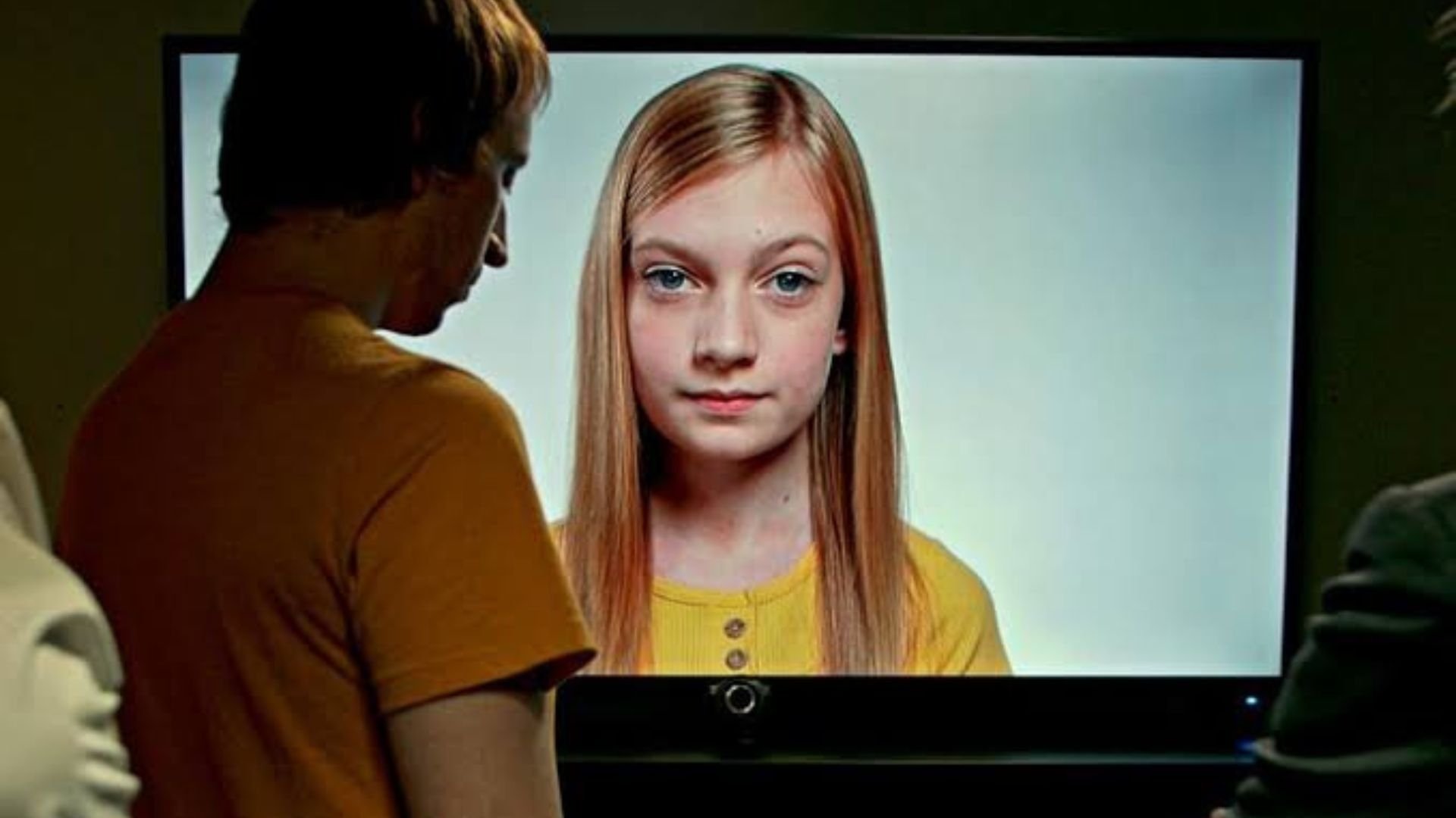 A man in front of TV with a girl on screen