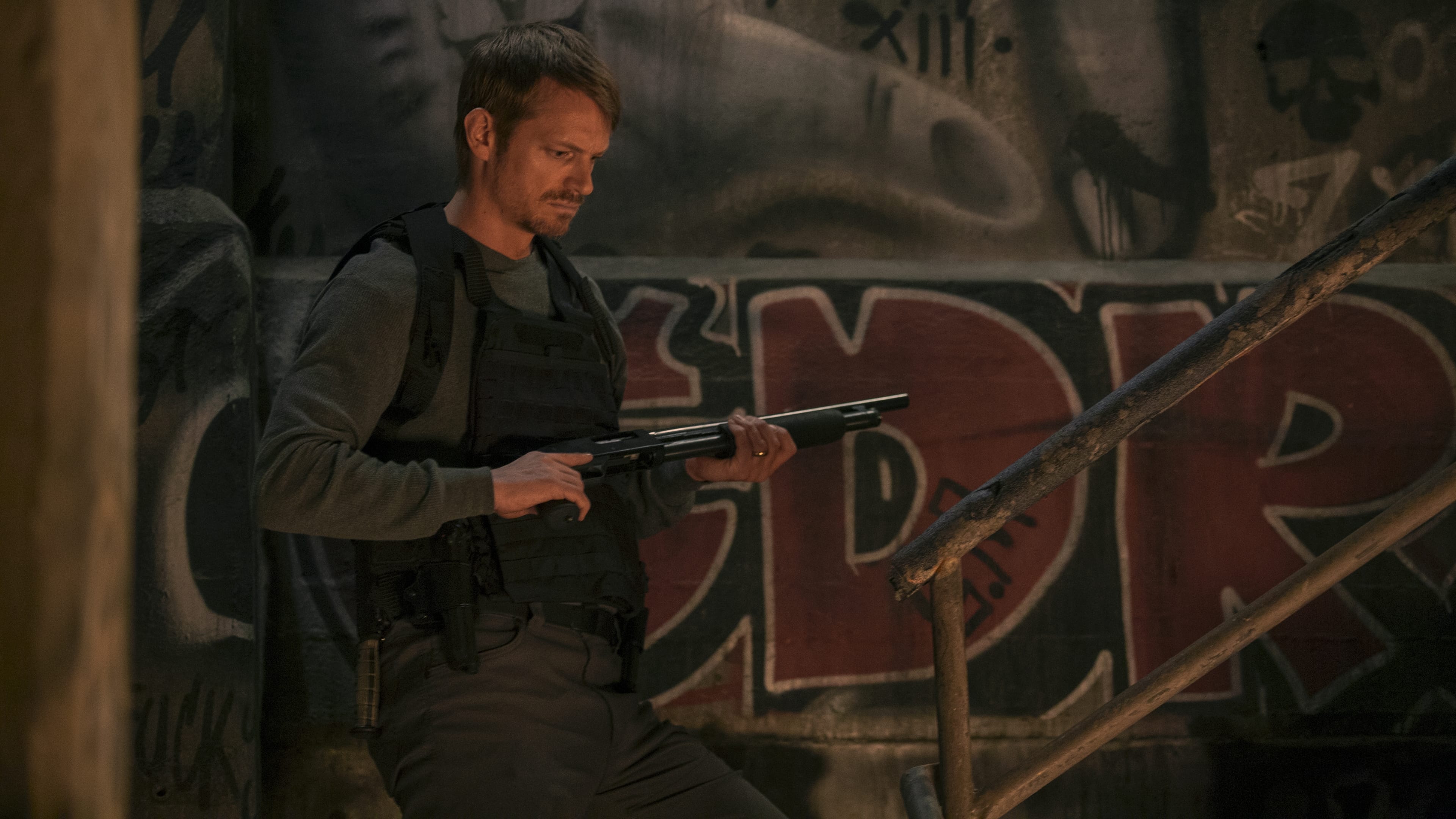 Joel Kinnaman holding a shotgun